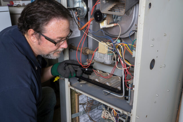 LM Wilson Technician Looking Over A Gas Furnace